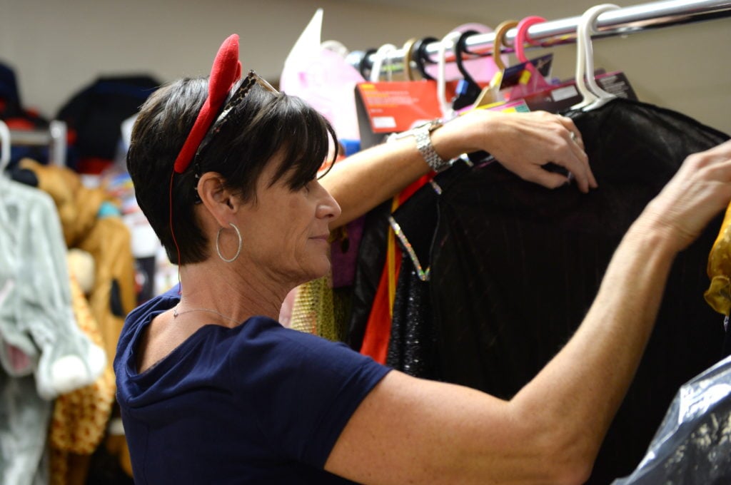 Judy sorts through costumes on distribution day, looking for the perfect match. Photo by Hurley Event Photography.