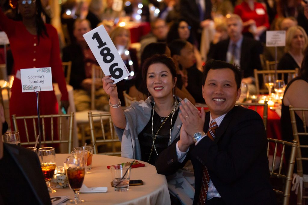 Attendees at the 2019 Feed the Hungry Gala raise their paddles during the fundraising portion of the evening program.