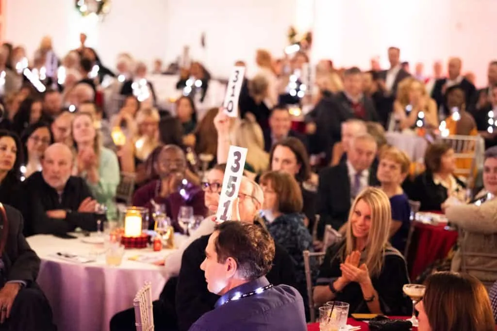 Guests of the Feed the Hungry Gala raised their paddles during the fundraising program at Interfaith Social Services’ signature event on Dec. 6 at Granite Links. Generous individuals and businesses raised $450,000 for Interfaith’s emergency food, mental health and homelessness prevention programs at the event. Credit –Matt Teuten Photography