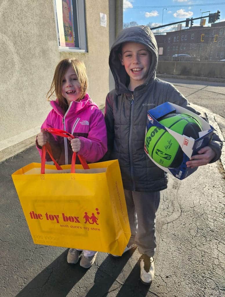 More than 400 South Shore individuals and 25 businesses and organizations signed up to sponsor families through Interfaith Social Services Help for the Holidays program, including this sister and brother pair who dropped off gifts to Interfaith in December.  Credit – Interfaith Social Services Courtesy Photo