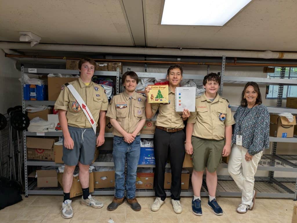 Alden Belfort, center, of Quincy's Troop 6, recently completed a Children's Book Drive for Interfaith for his Eagle Scout project, collecting thousands of books in his community.