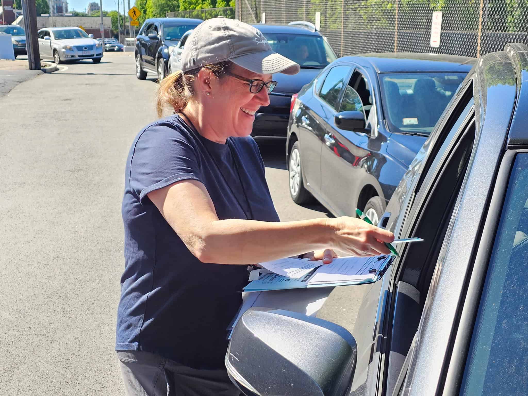 Interfaith volunteer at car checking in a client