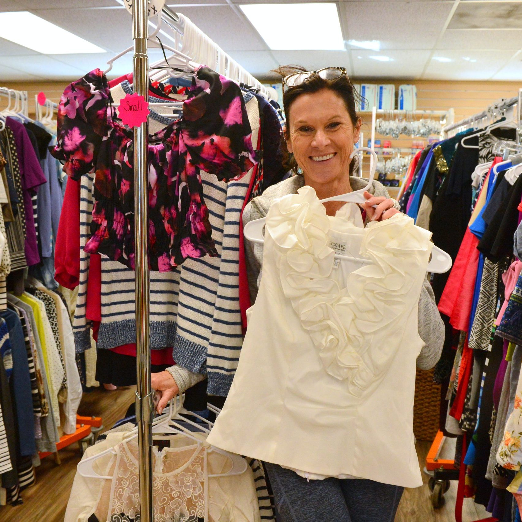 woman holding up shirt at Bureau Drawer Thrift Shop