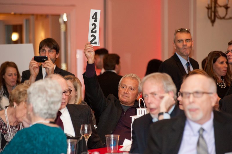 Guest John Tallarida holds up his paddle during the auction.